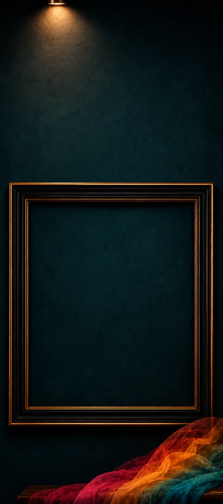 A deep-teal gallery wall lit from above, with a large empty black-and-gold portrait frame and a brass lamp on a draped bench.
